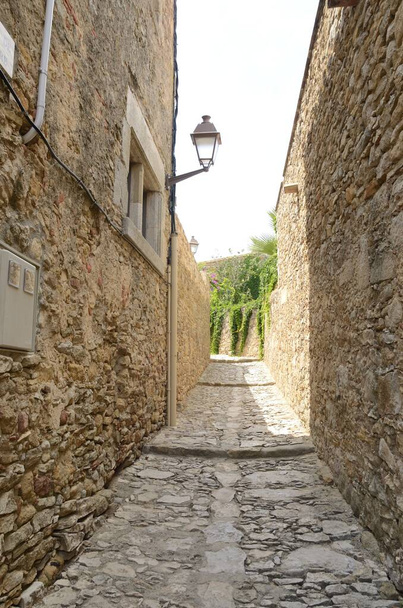Wąska uliczka schodkowa średniowiecznej wioski Peratallada, położonej w środku regionu Emporda w Gironie, Katalonia, Hiszpania. - Zdjęcie, obraz