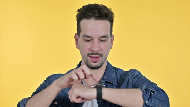 Portrait de jeune homme professionnel utilisant Smartwatch, fond jaune
 - Photo, image