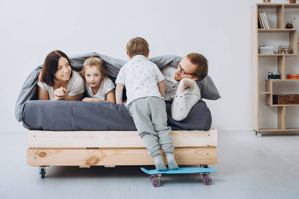 Family with preschool children playing skate in the room. - Photo, Image
