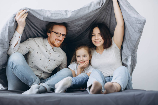 Young parents with children have fun in bed on weekends. - Photo, Image