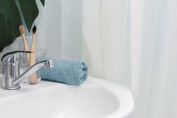 Nulový plýtvání. Eco přírodní bambusové zubní kartáčky, modrý ručník a šťavnatý na umyvadle. Zelený palmový list na pozadí. Kopírovat prostor - Fotografie, Obrázek
