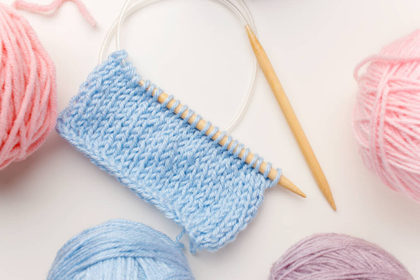 Conjunto de fios de lã, crochê, agulhas de tricô, nas cores azul, roxo e rosa no fundo branco.Vista superior
.  - Foto, Imagem