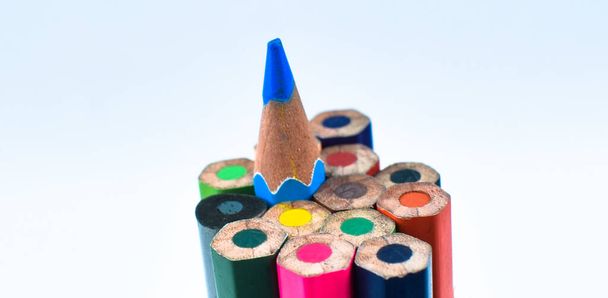 Vista lateral de uma pilha de lápis de cor diferente lápis de cor dispostos juntos em um fundo branco
 - Foto, Imagem
