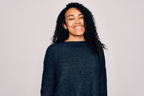 Young african american curly woman wearing casual sweater standing over white background with a happy and cool smile on face. Lucky person. - Photo, Image