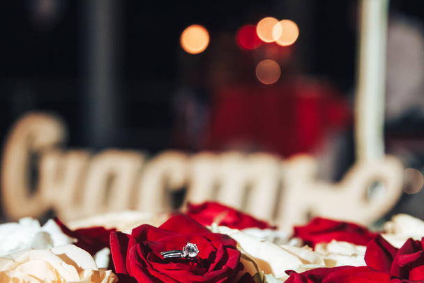 Anello nuziale su petali di rosa. L'iscrizione nella felicità russa
 - Foto, immagini
