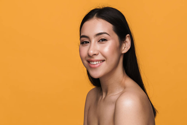 Beauty portrait of caucasian young brunette half-naked woman smiling with happy look isolated over yellow background - Fotoğraf, Görsel