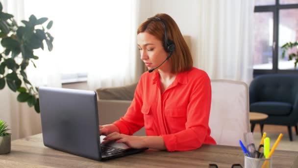 woman with headset and laptop working at home - Filmmaterial, Video