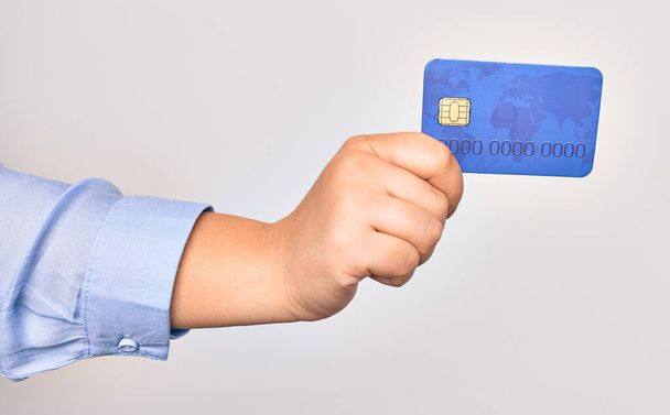 Kéz a kaukázusi fiatal nő gazdaság hitelkártya felett elszigetelt fehér háttér - Fotó, kép