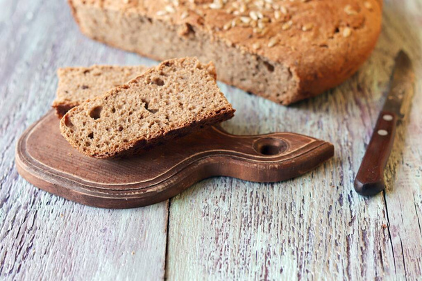 Домашній хліб нарізаний скибочками на дерев'яній дошці, здорова їжа, цільне зерно, органічний продукт
 - Фото, зображення