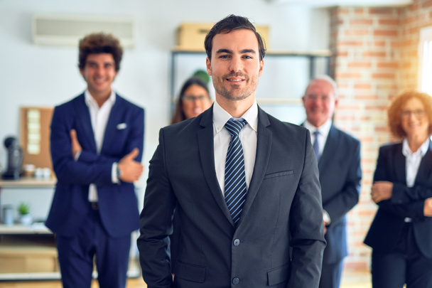 Grupo de empresários sorrindo feliz e confiante em uma reunião. De pé com sorriso no rosto olhando para a câmera no escritório
. - Foto, Imagem