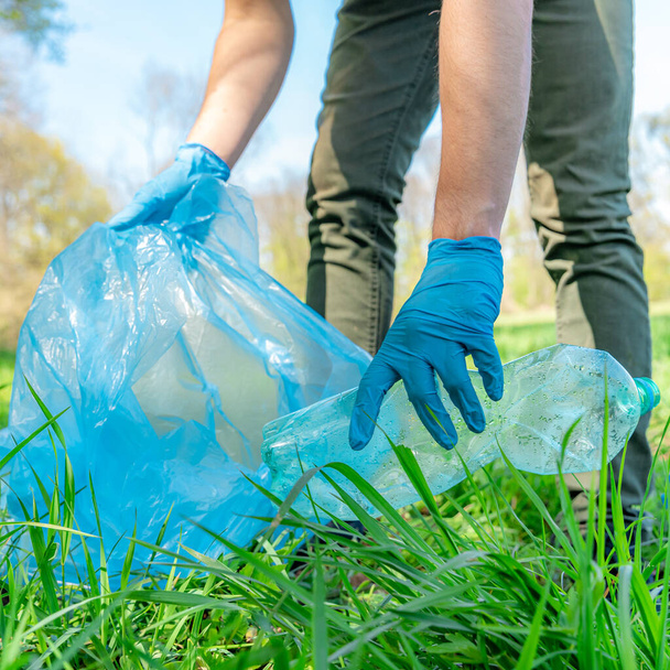 Reinigung der Natur durch das Sammeln von Plastikmüll, Plastikflaschen aus dem Getränk verursachen eine ökologische Katastrophe - Foto, Bild