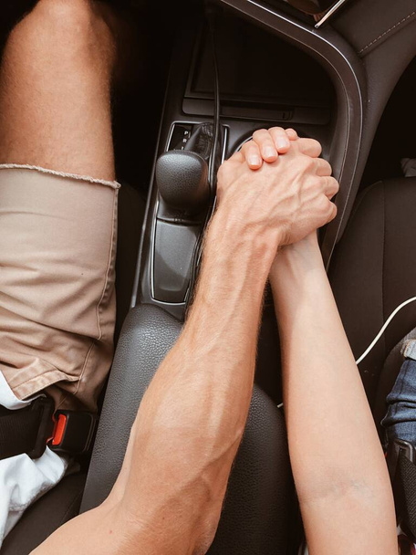 Close up woman and man in love sitting in car. Two people holding hands. Symbol sign sincere feelings, compassion, loved one, say sorry. Trusted friend, true friendship and love concept. - Photo, Image
