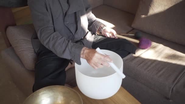 A qigong master conducts meditation using a gong and Crystal bowl, Crystal Tibetian singing bowl, a master meditates receives energy for the body - Materiaali, video