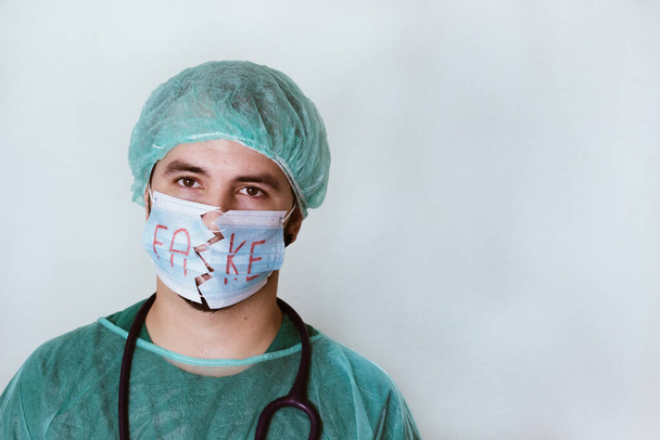 médico com uma máscara de proteção rasgada e costurada
 - Foto, Imagem