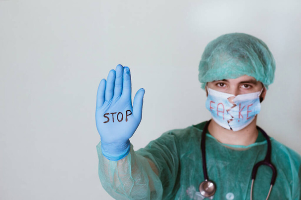 Доктор с поднятой рукой, в перчатке которого слово "стоп"
 - Фото, изображение