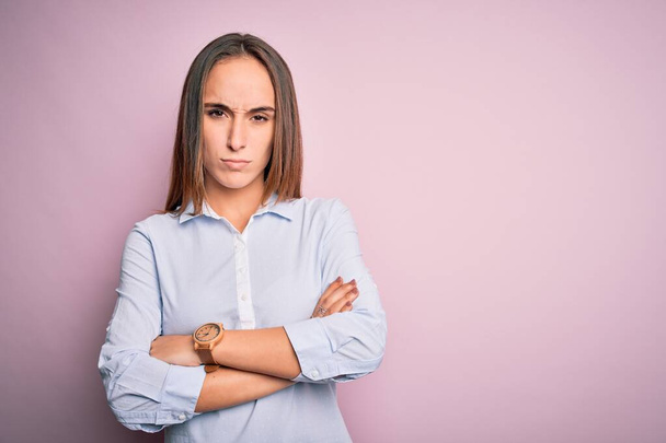 Young beautiful businesswoman wearing elegant shirt standing over isolated pink background skeptic and nervous, disapproving expression on face with crossed arms. Negative person. - Foto, Imagem