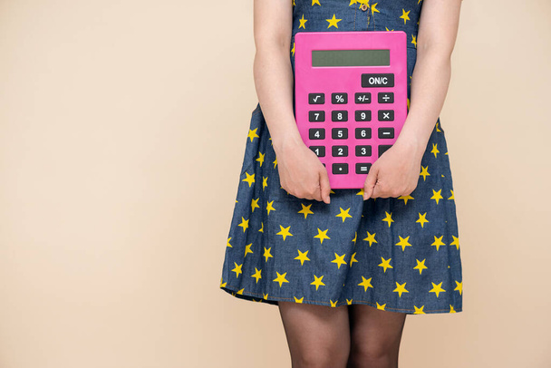 Woman with a big calculator in the hands close up isolated on light background with copy space. - Photo, Image
