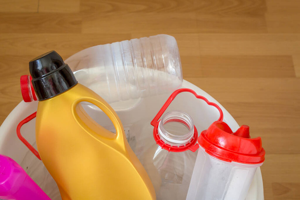 Las botellas de plástico usadas se colocan en un recipiente. Concepto: Los residuos plásticos deben recogerse por separado de otros residuos para su reciclado
. - Foto, Imagen