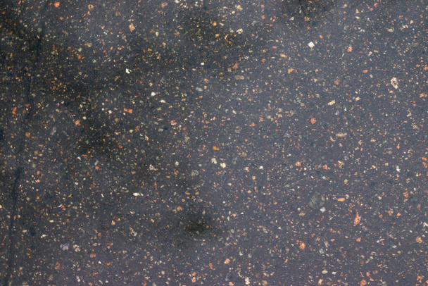 Asfalt ya da asfalt yolda yağmur, bahar boyunca yüksek kontrastlı dalgalanmalar yaratır. Arkaplan dokusu - Fotoğraf, Görsel