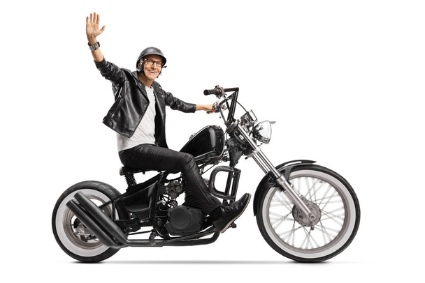 Elderly biker in leather jacket riding a chopper and waving isolated on white background - Φωτογραφία, εικόνα