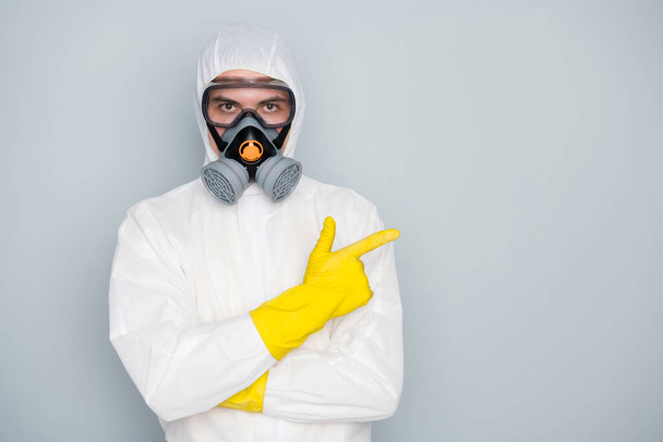 Photo of specialist disinfectant clean public places show pandemic rules highly recommend citizens stay home social isolation wear hazmat protective suit isolated grey color background - Фото, зображення