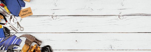 Happy Fathers Day Geschenkanhänger mit Eckrand aus Krawatten, Geschenken und Werkzeugen auf weißem Holzbanner Hintergrund. Overhead-Ansicht mit Kopierraum. - Foto, Bild