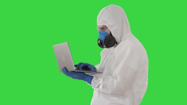 Medical doctor in white protective uniform using laptop on a Green Screen, Chroma Key. - Séquence, vidéo
