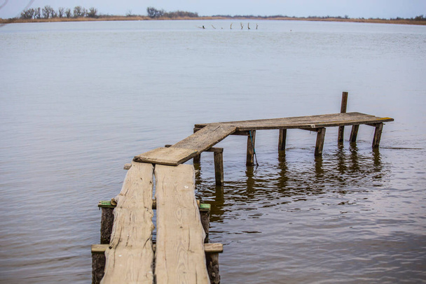 Riverside with old weathered wooden pier - Foto, Imagen