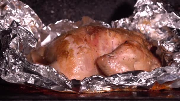 Cooking roasted whole chicken in foil in hot oven closeup. Juicy tender chicken with golden skin. Cooking yourself during the coronovirus - Video