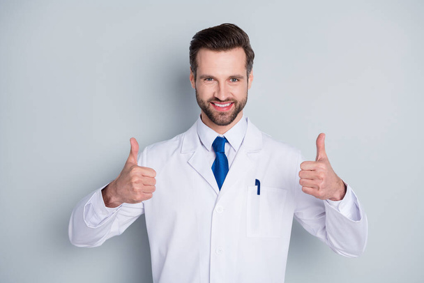 Photo of handsome doc practitioner man patients consultation virology clinic raise thumbs up approving equipment quality wear white lab coat blue neck tie isolated grey color background - Fotó, kép