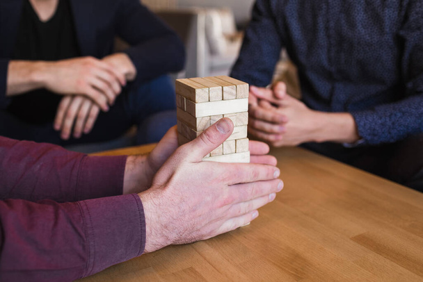 Guys play jenga in a stylish loft cafe with a modern design - Foto, Imagen