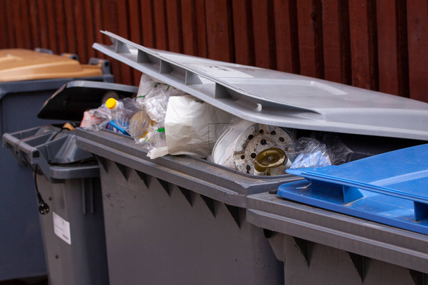Großrad-Mülltonnen mit geöffneten Litern überfüllt mit Müll wie Hausmüll, Müll, Recycling und Gartenabfällen. - Foto, Bild