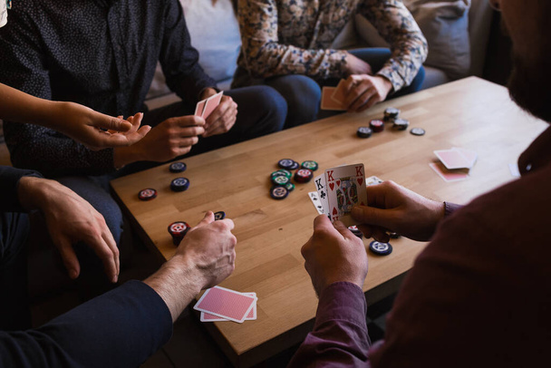 Several men are playing poker in a cafe, holding cards in their hands - Foto, immagini