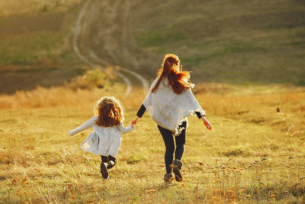 Mother with little daughter playing in a autumn field - Foto, Imagem