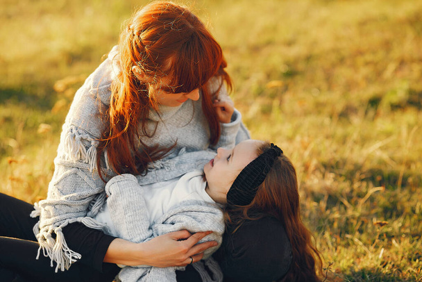 Mother with little daughter playing in a autumn field - Foto, imagen