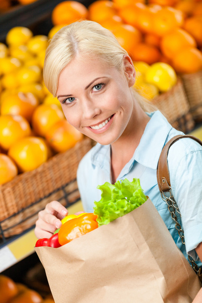 Girl holds paper bag with fresh vegetables - Zdjęcie, obraz