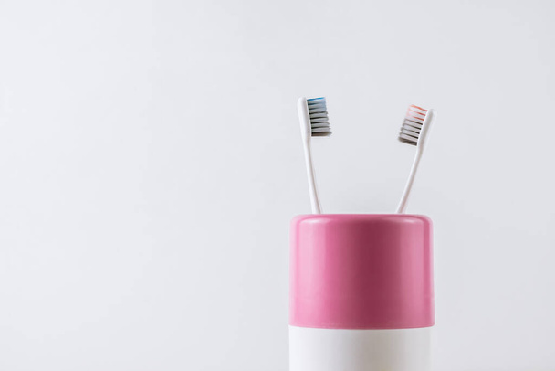 Different types of toothbrushes in a white cup.  - Foto, Bild