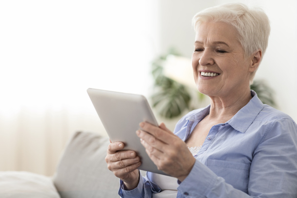Comunicación en línea. Happy Senior Lady Navegación por las redes sociales en la tableta digital
 - Foto, Imagen