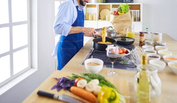 Man preparing delicious and healthy food in the home kitchen - Φωτογραφία, εικόνα