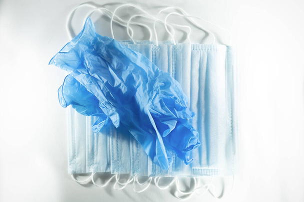 disposable blue medical gloves and medical masks on a white background. - Fotografie, Obrázek