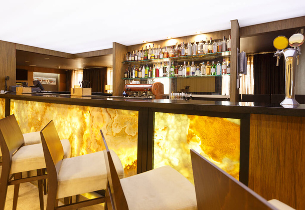 Φουτουριστικό μπαρ ξενοδοχείου. Κίτρινος-καφέ σχεδιασμός με ψηλές καρέκλες - Φωτογραφία, εικόνα