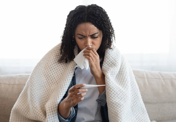 Symptômes du coronavirus. Malade femme noire vérifier la température de son corps à la maison
 - Photo, image