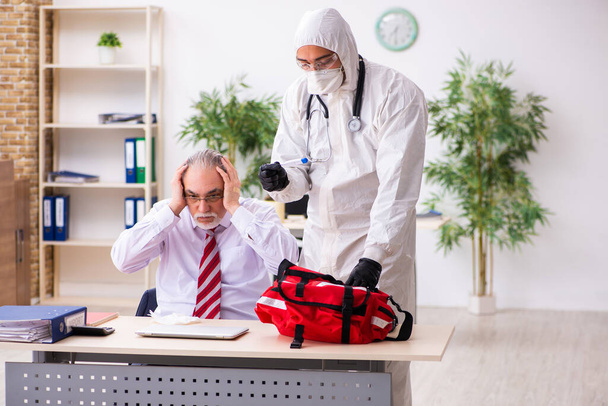 Old employee catching coronavirus at workplace - Photo, Image