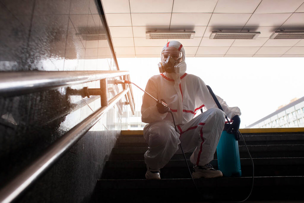 Coronavirus pandemia. desinfiointipalvelutyöntekijä suojapuvussa puhdistaa kaupungin kadut viruksilta ja kemikaaleilta, kaupungin eristäminen
 - Valokuva, kuva
