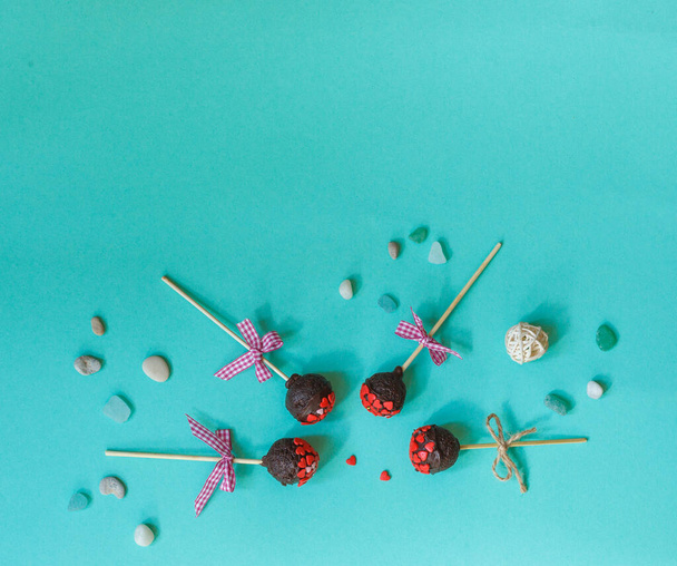 four homemade chocolate cake pop with hearts on a blue background, top view with space - Photo, Image