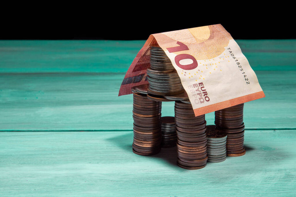 будинок з монет і банкнот євро на зеленому столі
 - Фото, зображення