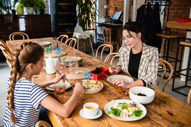Οικογένεια δύο ατόμων που γευματίζουν σε ένα καφέ - Φωτογραφία, εικόνα