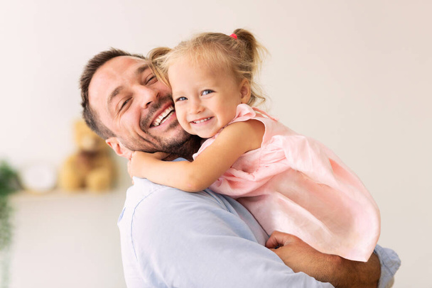 Caucásico padre sosteniendo su lindo cariñoso hija
 - Foto, Imagen