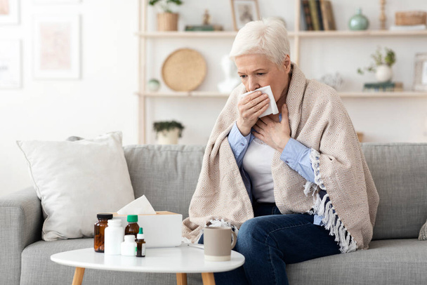 Síntomas del Coronavirus. Mujer mayor enferma tosiendo duro en casa
 - Foto, Imagen