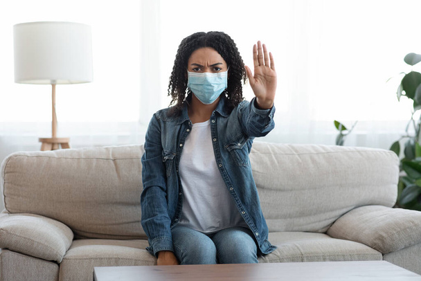 コロナウイルスを止めなさい。医者のマスクで黒人女性が自宅で停止ジェスチャー - 写真・画像